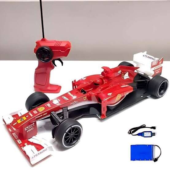 Red toy Formula 1 car with remote control and accessories on a white surface available at Juniors Toys