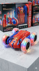 Spider-Man remote control stunt car with glowing wheels on a concrete surface, surrounded by packaging available at Juniors Toys