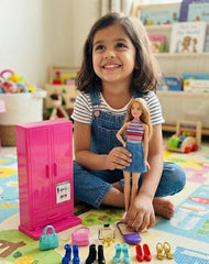 Child holding a doll with a toy wardrobe and accessories on a colorful mat available at Juniors Toys