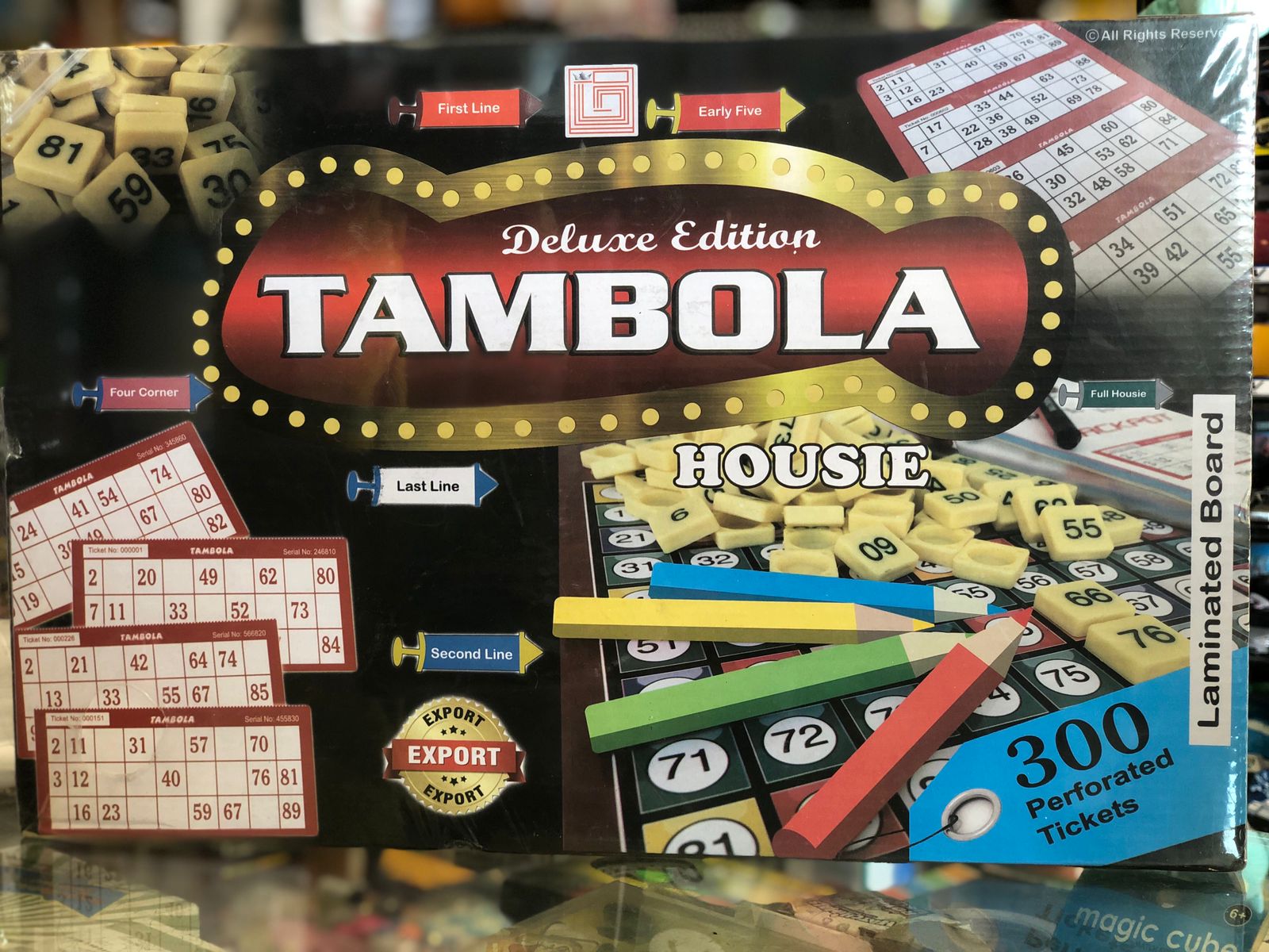 Deluxe Edition Tambola Housie game box with dice and tickets on a reflective surface available at Juniors Toys