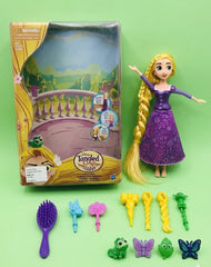Toy figure of Rapunzel from Disney's 'Tangled' with accessories on a green background available at Juniors Toys