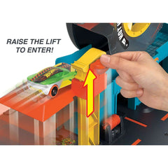 Hot Wheels City Super Twist Tire Shop play set with a hand demonstrating the twisting stunt action available at Juniors Toys