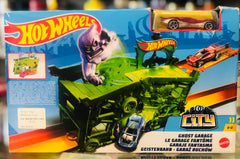 The unboxed Hot Wheels Ghost Garage set with its accessories, a purple ghost, and cars, displayed next to the original retail packaging available at Juniors Toys