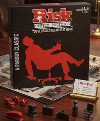 Risk Office Politics game box with office-themed accessories on a wooden surface available at Juniors Toys