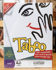 Taboo game box with a stylized face design on a wooden surface available    at Juniors Toys  