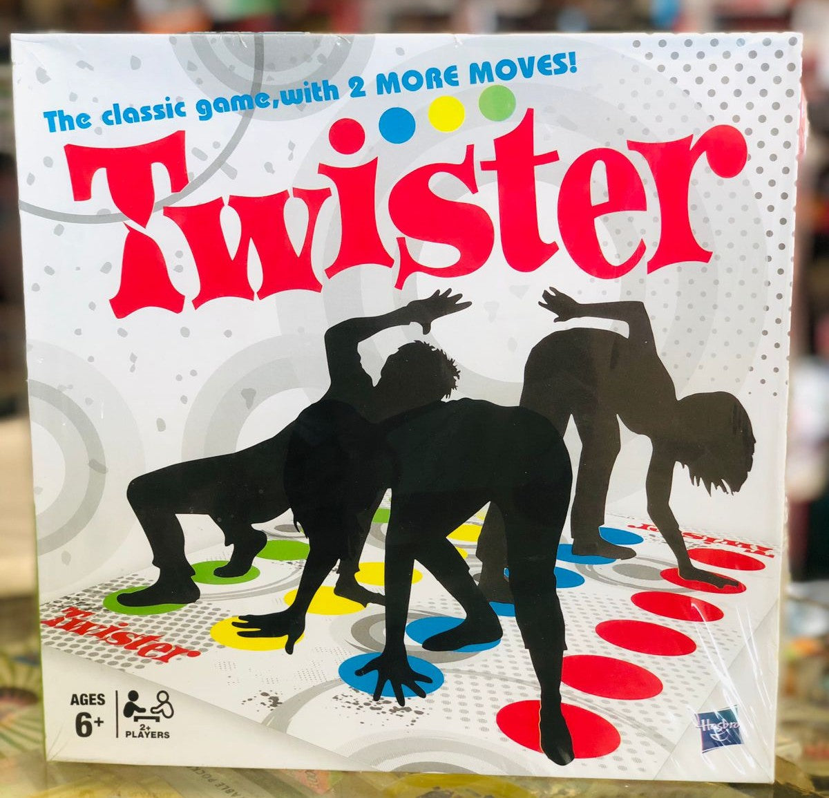 Twister game box with silhouettes of people playing availble at Juniors Toys